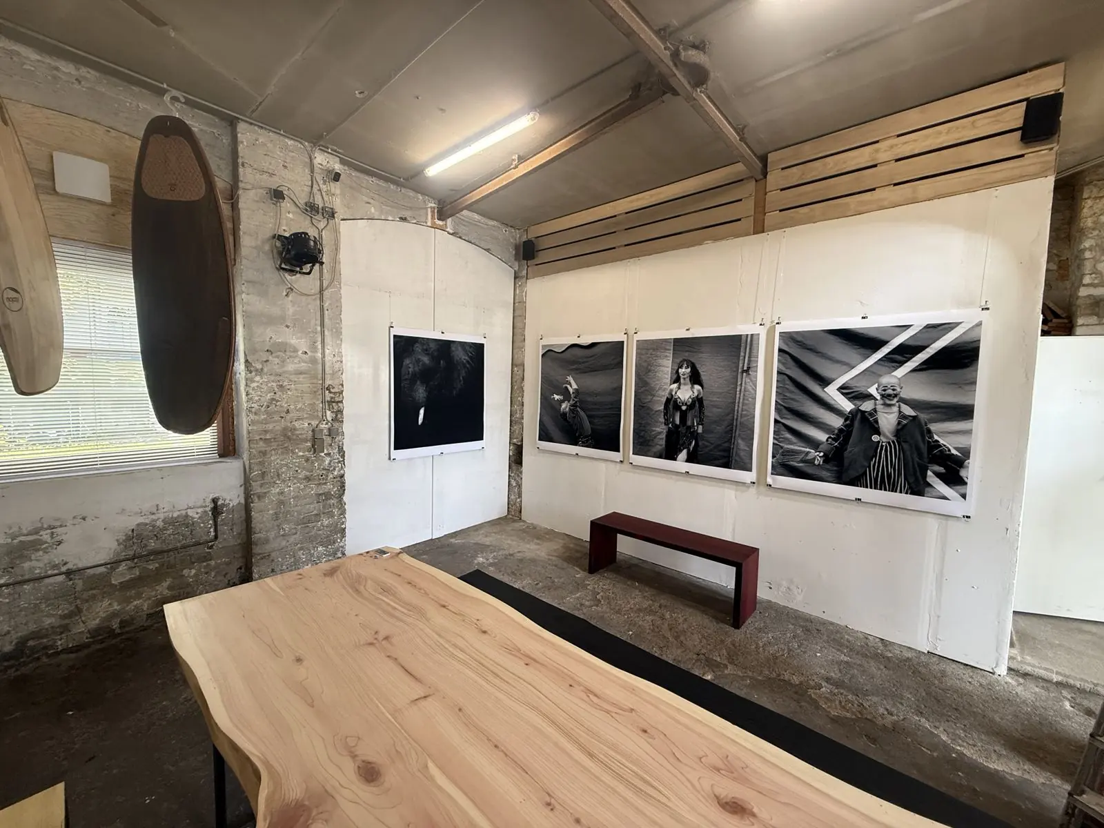 Großformatige Schwarzweiß-Fotografien von Arendt Schmolze im Ausstellungsraum, davor ein Holztisch